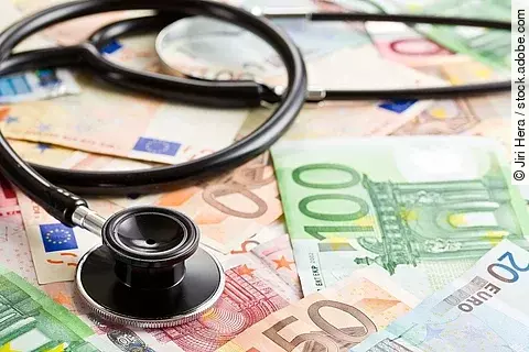 Stethoskop liegt auf Geldscheinen.