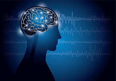 Illustration eines menschlichen Gehirns im Körper. Im Hintergrund sind EEG-Messwerte abgebildet. 