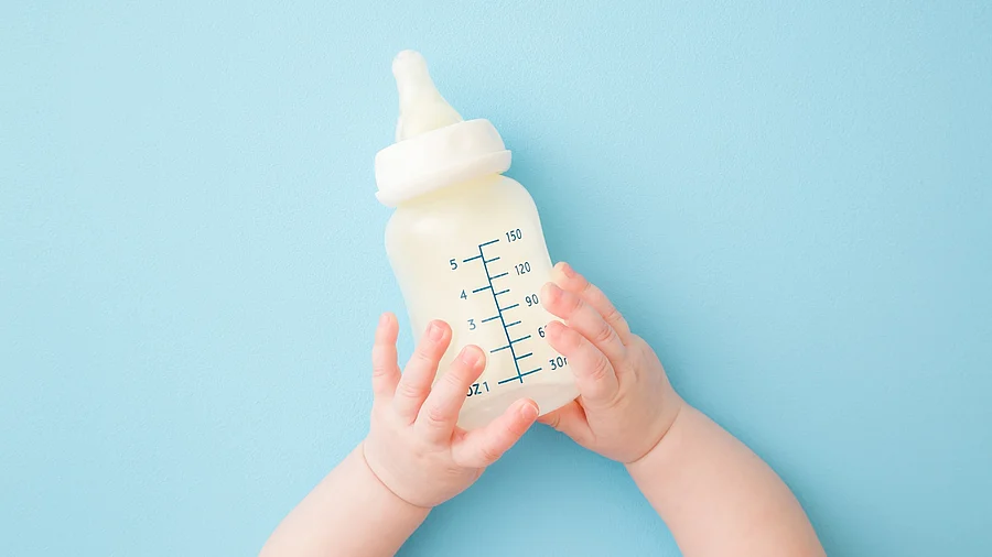 Babyhände halten eine Trinkflasche Babyhände halten eine Trinkflasche