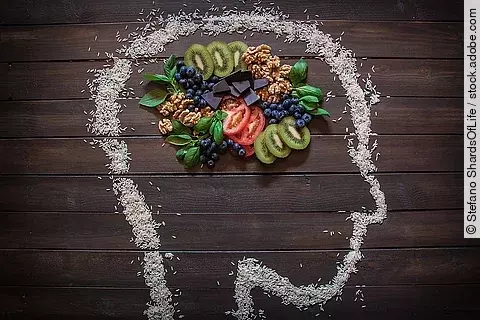 Nüsse, Beeren, Kiwi, Tomaten in einem mit Kreide gezeichneten Kopf