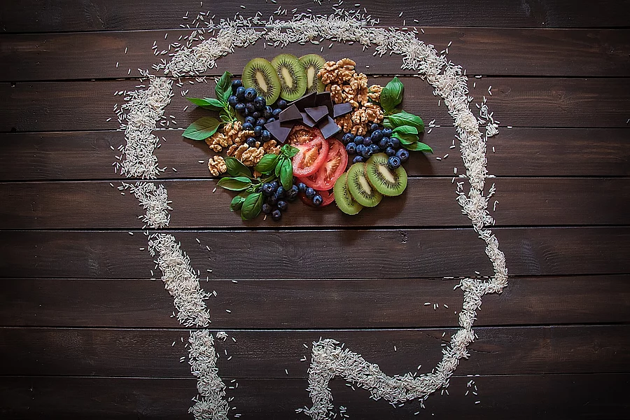 Nüsse, Beeren, Kiwi, Tomaten in einem mit Kreide gezeichneten Kopf