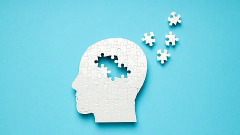 Kopf als weißes Puzzle, ein paar Puzzlesteine außerhalb des Kopfes 