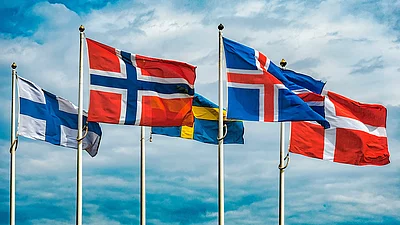 Flaggen von Skandinavien vor blauem Himmel