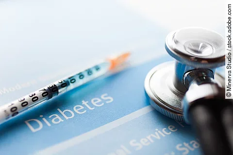 Spritze und Stethoskop liegen auf einem Schriftzug Diabetes