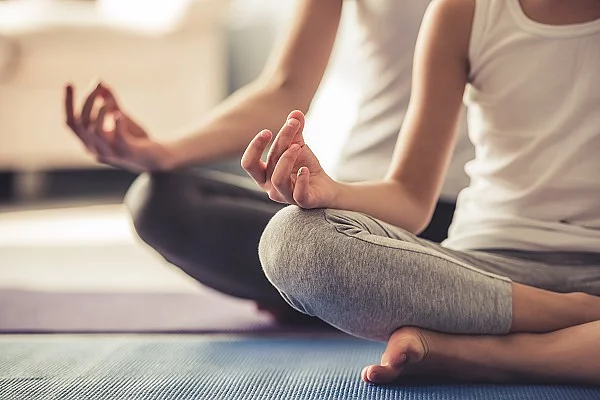Zwei Frauen machen Yoga auf einer Matte.