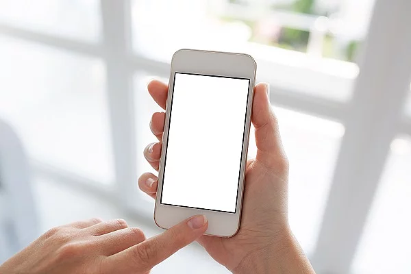 Women hands holding white phone with isolated screen background Frauenhände halten weißes Smartphone