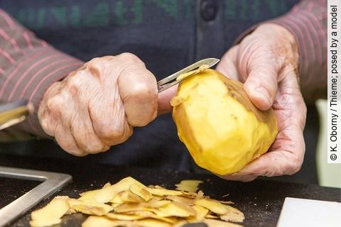Seniorinnenhände schälen Kartoffeln