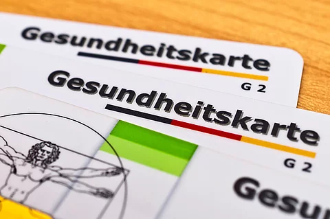 Auf einem Tisch liegen zwei Gesundheitskarten.