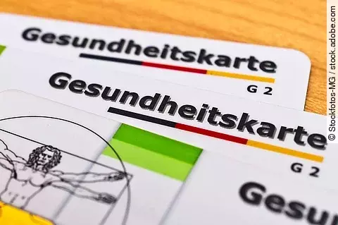 Auf einem Tisch liegen zwei Gesundheitskarten.