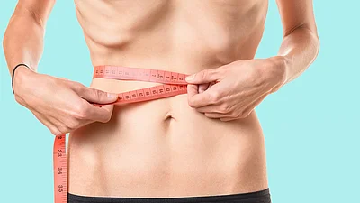 Untergewichtige Frau misst ihren Taillenumfang