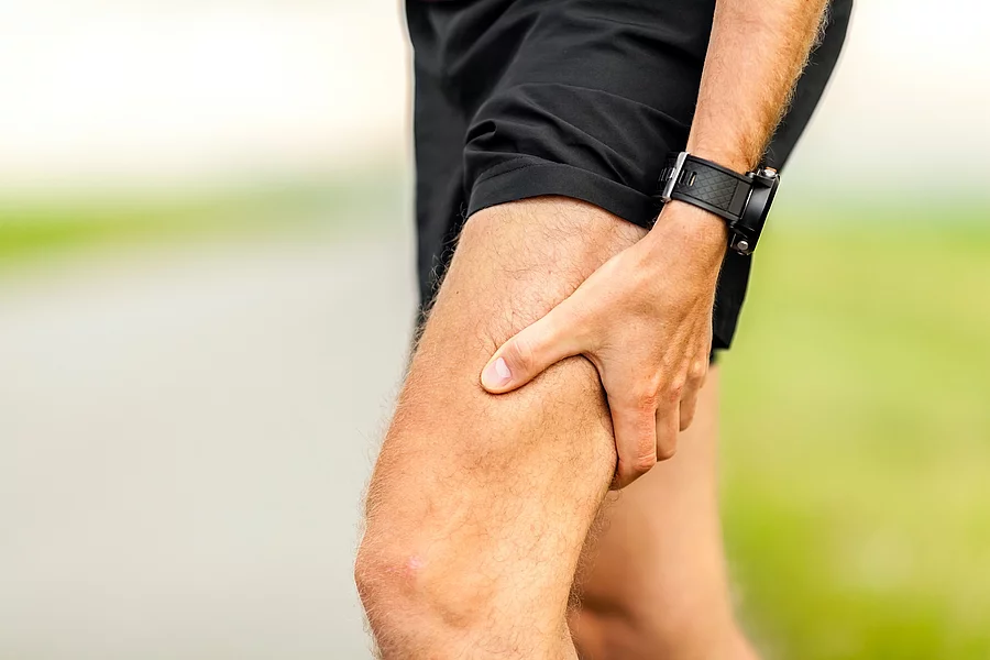 Läufer in Sportsachen hält sich den schmerzhaften Oberschenkel
