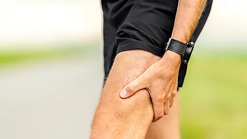 Läufer in Sportsachen hält sich den schmerzhaften Oberschenkel