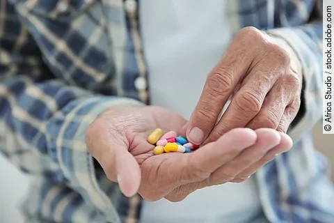 Senior hat Tabletten auf seiner Hand.