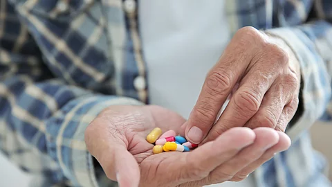Senior hat Tabletten auf seiner Hand.