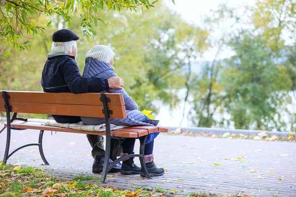 Senioren-Paar sitzt auf einer Bank im Park. 