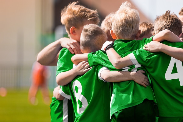 Kinder-Fußballteam. Jungs stehen in einem Kreis und umarmen sich. 