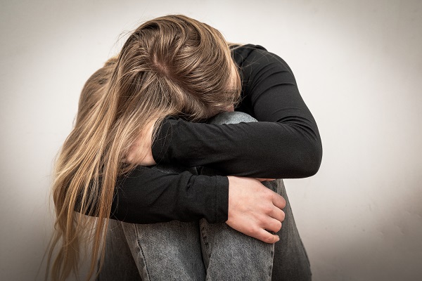 Junge Frau hat Kopf verborgen, Sorgen, Angst