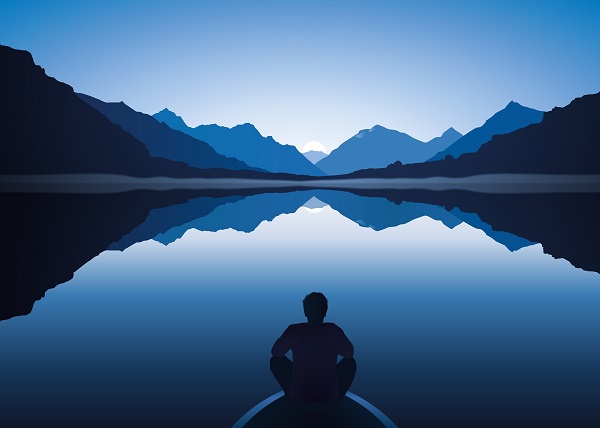 Mann sitzt auf Bootssteg am See von Bergen umgeben