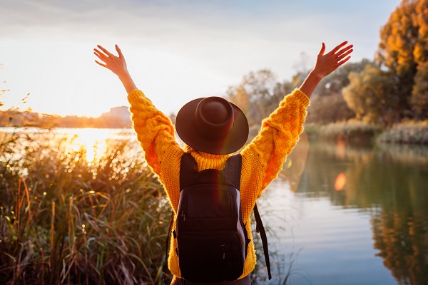 Frau mit Rucksack am See, Freude