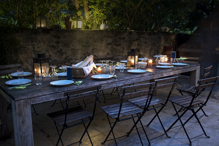 large rustic table prepared for a outside dinner at night Esstisch, Social Eating, gemeinsam essen, Ernährung